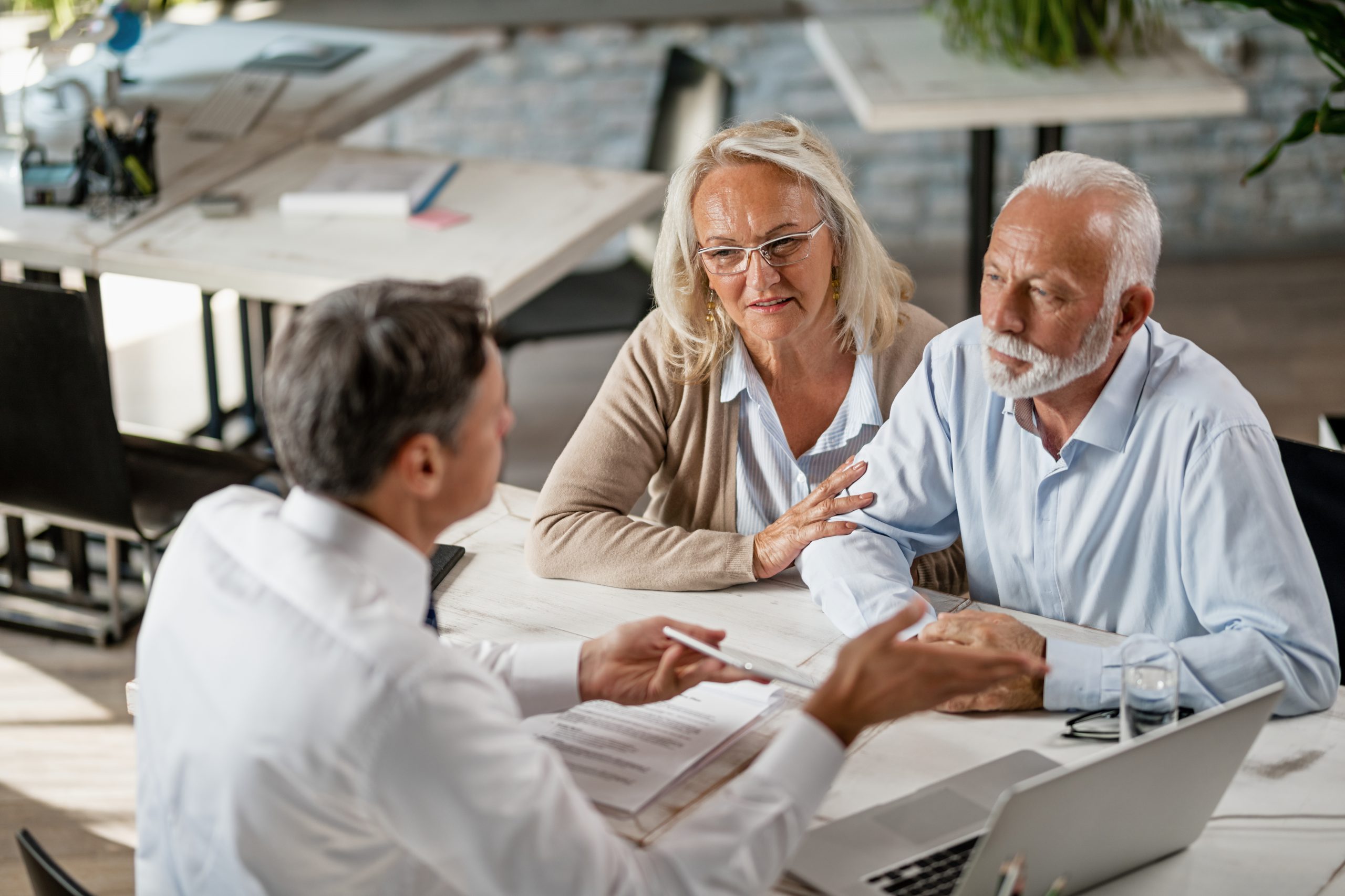 Senior couple talking to agent on a meeting in the office. Senior couple talking to agent on a meeting in the office